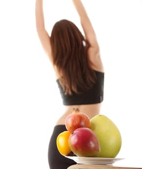 Healthy fruits with fitness girl in background, isolated o white