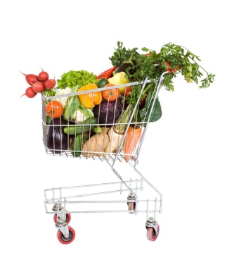 Shopping cart filled with fresh vegetables - isolated
