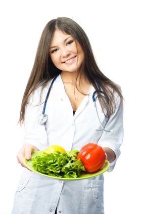 Beautiful young doctor suggesting us eating fresh vegetables