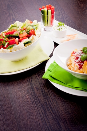 collection of different plates with healthy food pasta salad vegetables on wooden table