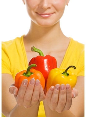 Girl holding sweet colorful peppers in her hands