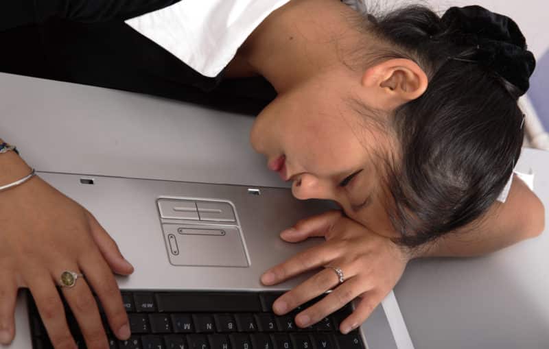 Jeune fille qui s'est endormi sur sin portable. Signe d'une fatigue trop accumulée. Trop de boulot ou d'études.