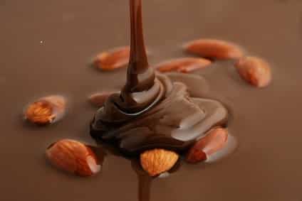 Close-up of melted chocolate pouring on almonds